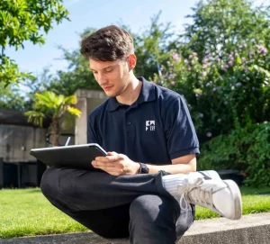 Das Bild zeigt einen Mann, der draußen sitzt und am Tablet mit der kwp-bnWin.net Software arbeitet.